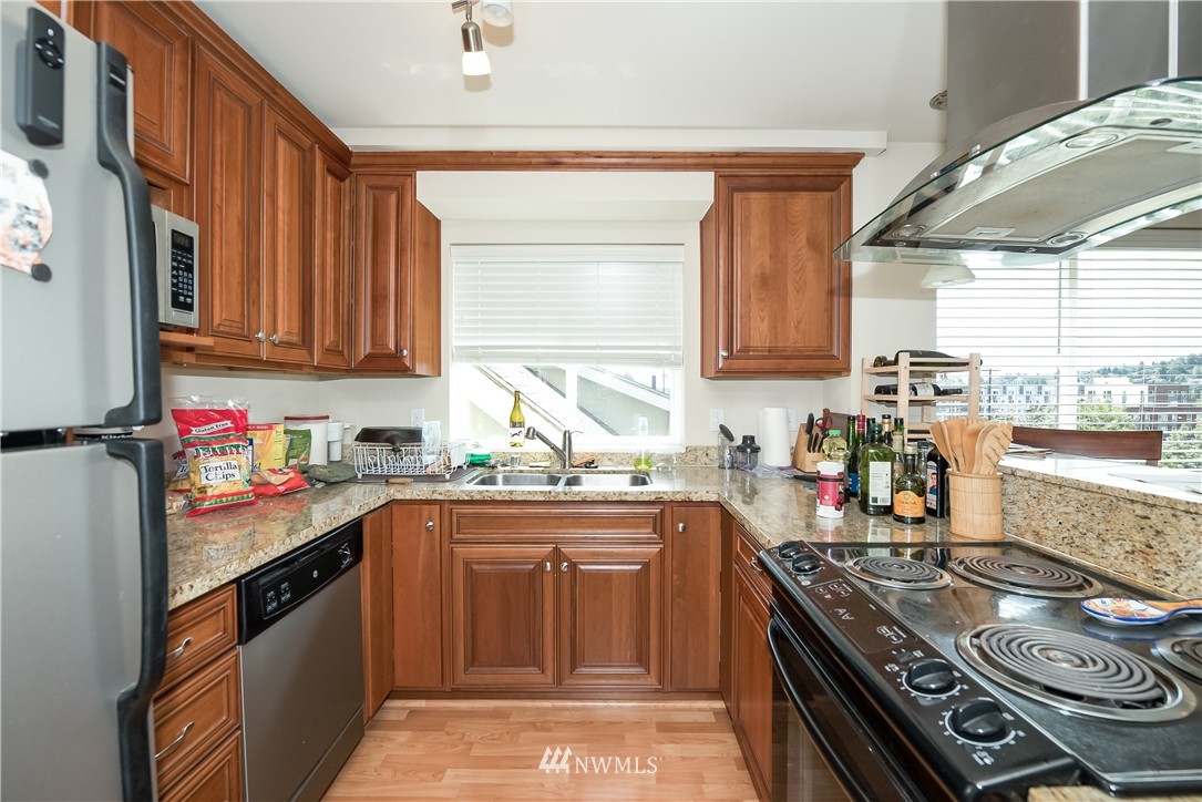 3232 15th Avenue West Seattle, WA 98119 - Photo 16 of 18 a kitchen with a sink stove top oven and cabinets