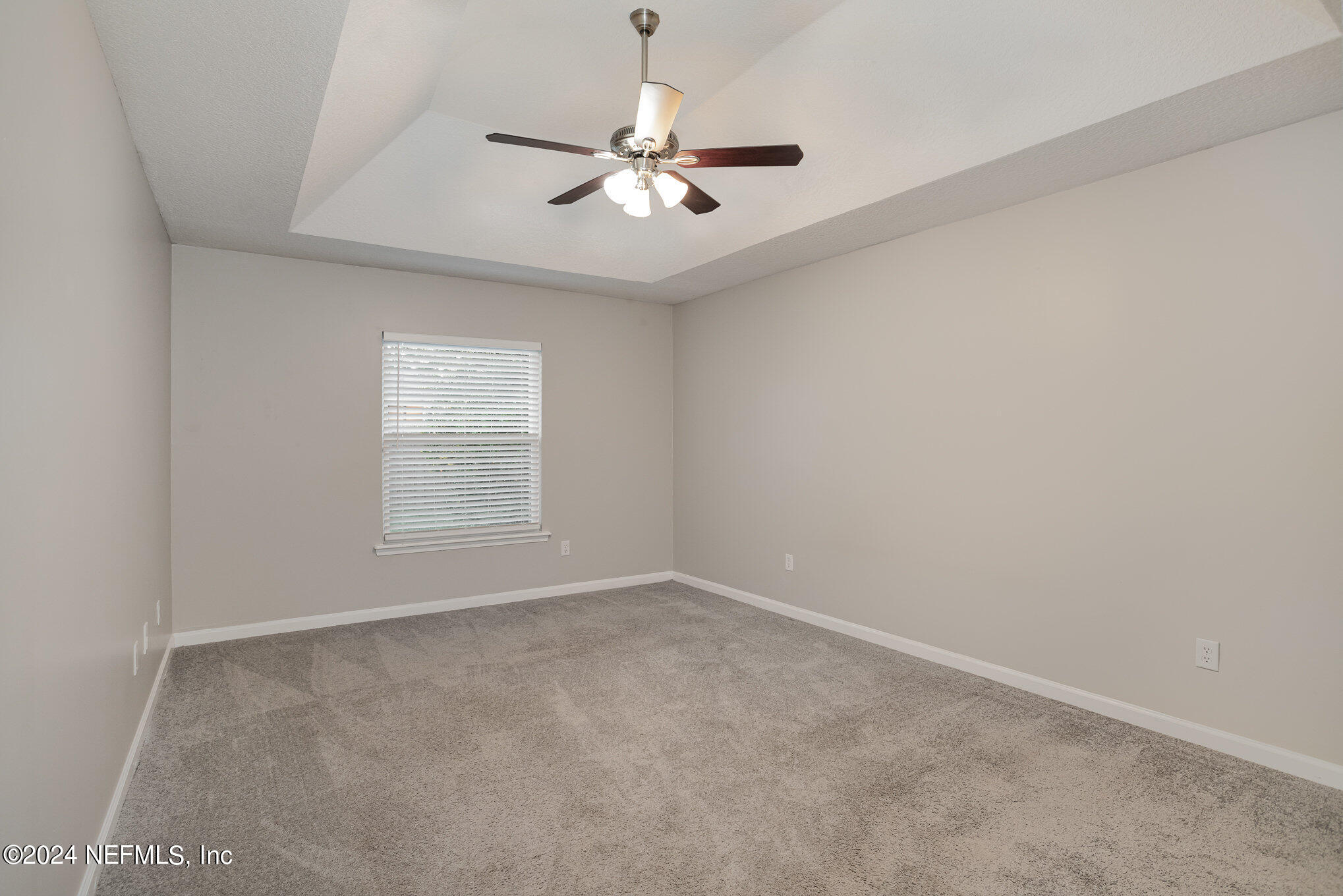 4595 Prunty Avenue Jacksonville, FL 32205 - Photo 12 of 15 an empty room with a chandelier fan and windows