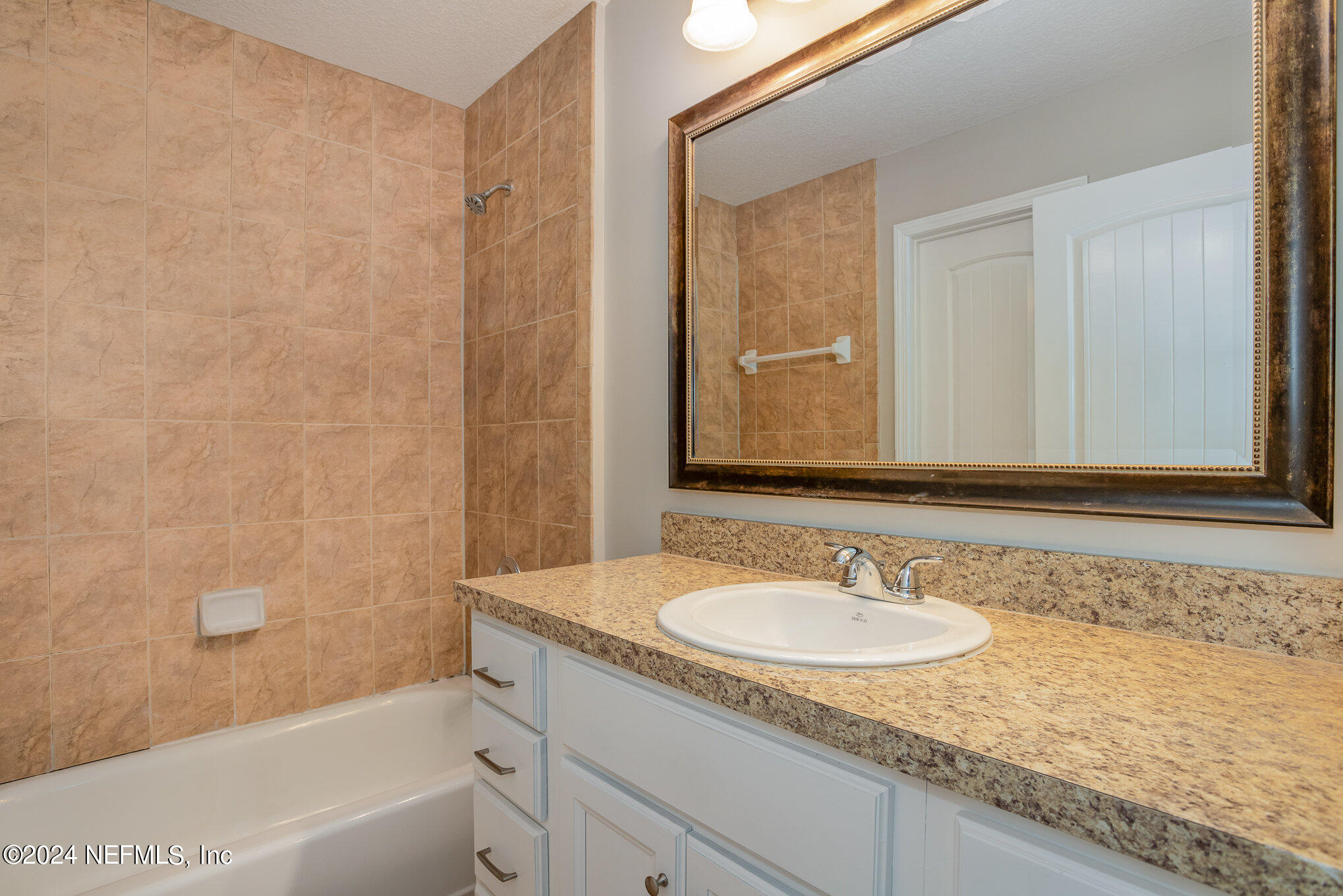 4595 Prunty Avenue Jacksonville, FL 32205 - Photo 13 of 15 a bathroom with a granite countertop sink a mirror and a bathtub