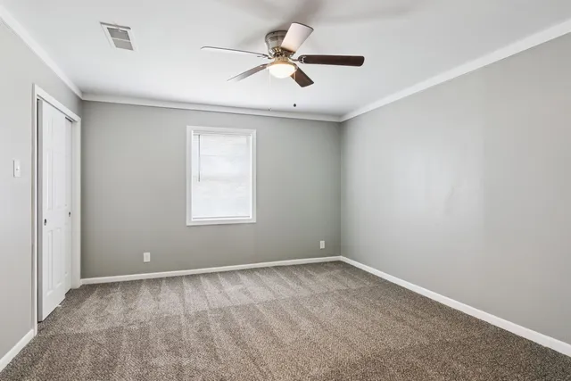 an empty room with a window and a fan