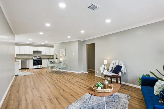 a living room with furniture a rug and kitchen view