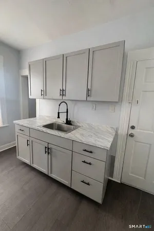 a kitchen with cabinets appliances and a wooden floor