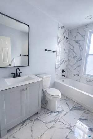 a bathroom with a toilet sink and mirror