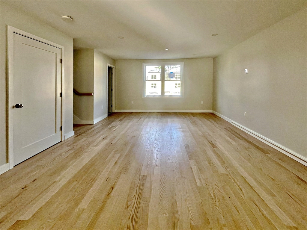 14 Dyer Street, Unit 14 Rockland, MA 02370 - Photo 6 of 16 an empty room with wooden floor and windows