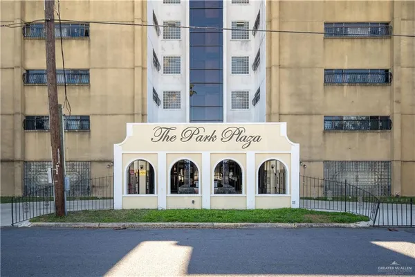a view of a white building with a yard
