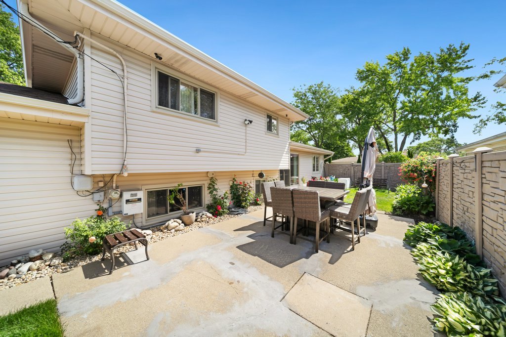 365 West Myrick Avenue Addison, IL 60101 - Photo 34 of 49 a view of a patio with table and chairs potted plants and a large tree