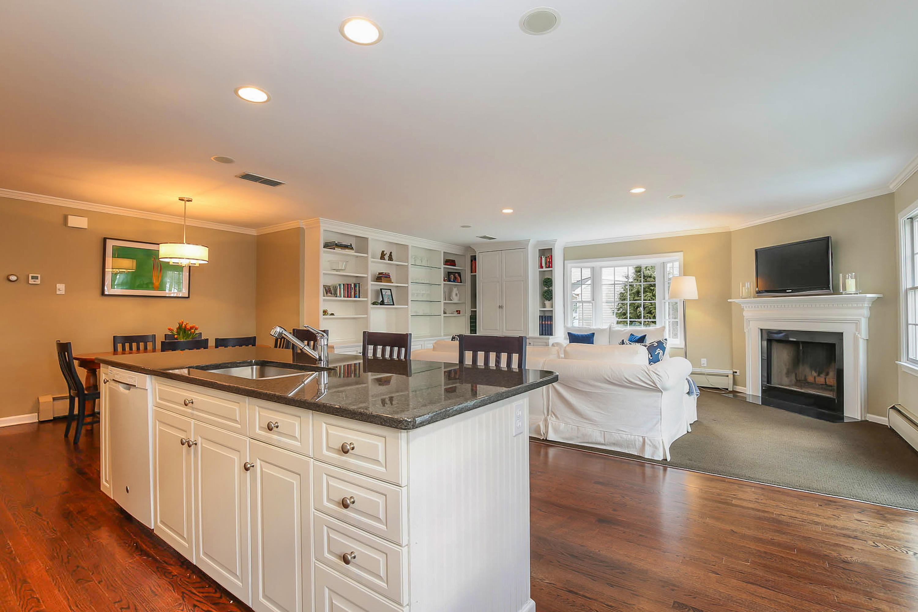 25 Miles Road Darien, CT 06820 - Photo 12 of 30 a kitchen with granite countertop a sink and white cabinets with wooden floor