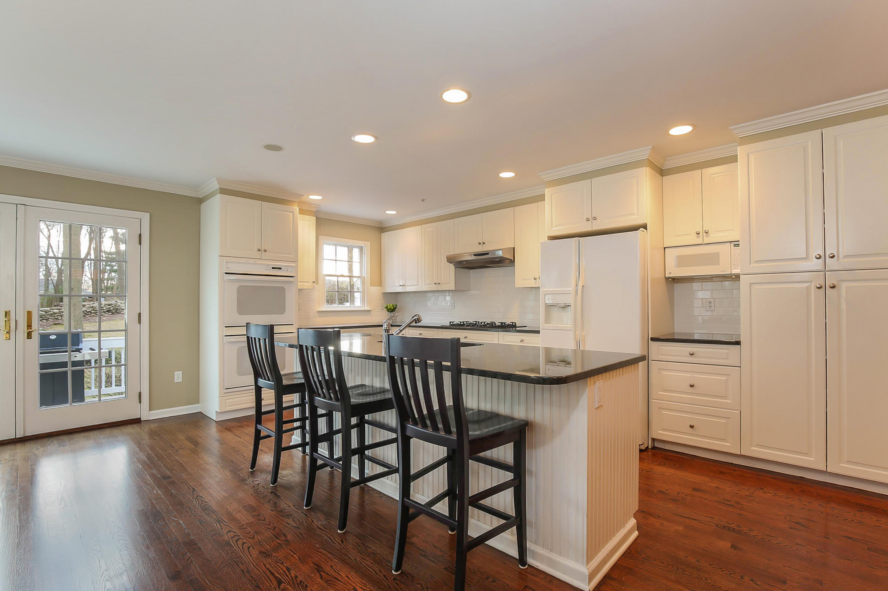 25 Miles Road Darien, CT 06820 - Photo 10 of 30 a kitchen with stainless steel appliances kitchen island granite countertop a table chairs sink refrigerator and cabinets