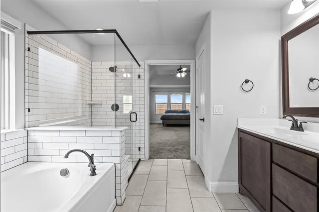 a en suite bathroom with a sink a mirror and a bathtub
