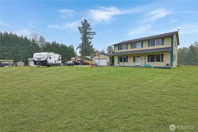 a view of a house with a big yard and large trees