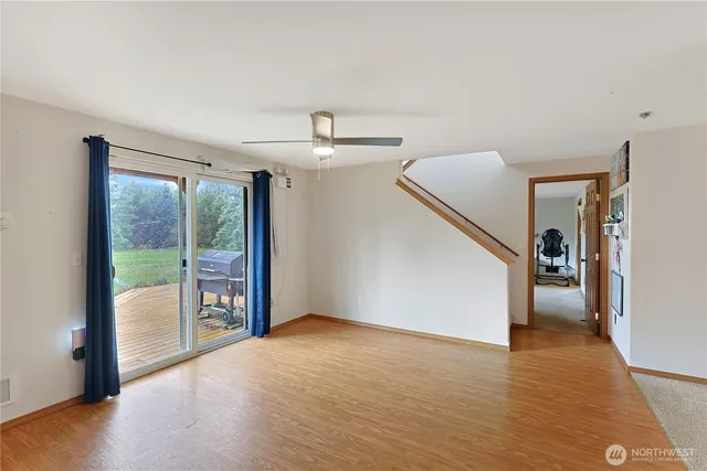 a view of a livingroom with wooden floor and stairs