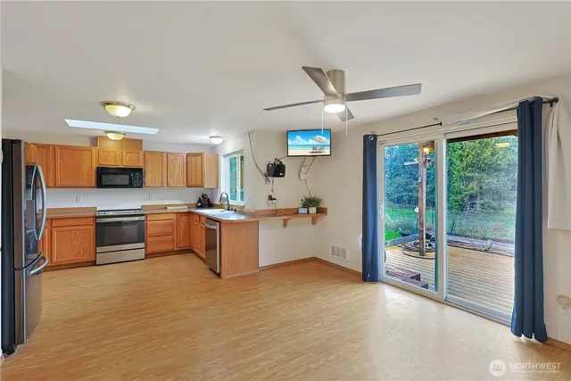 a large kitchen with stainless steel appliances kitchen island granite countertop a refrigerator and a stove top oven
