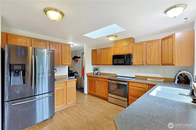 a kitchen with stainless steel appliances granite countertop a refrigerator stove microwave and sink