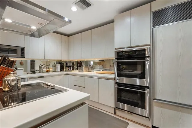 a kitchen with a sink dishwasher and a stove with wooden floor