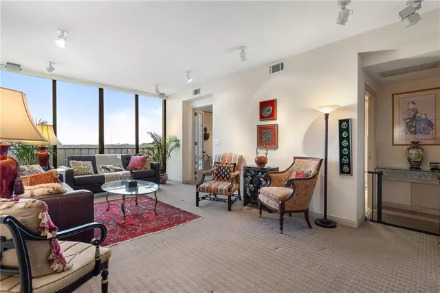 a living room with furniture a rug and a large window