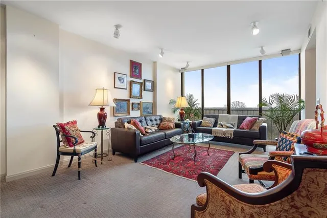 a living room with furniture a flat screen tv and a rug