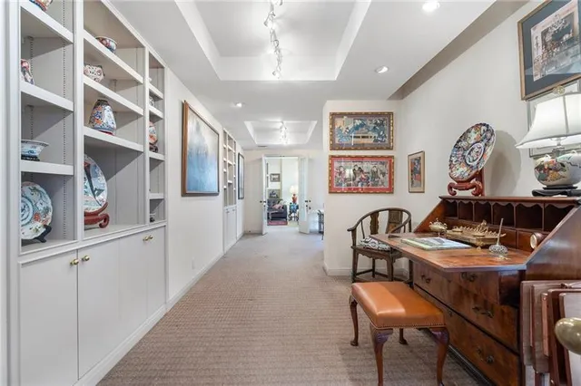 a spacious bedroom with a bed and a lamp on dresser