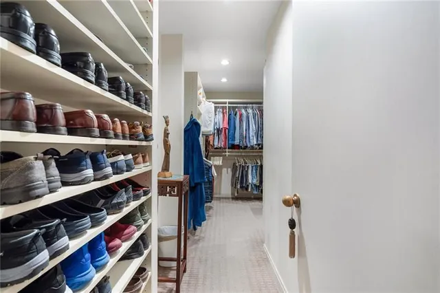 a view of walk in closet with clothes