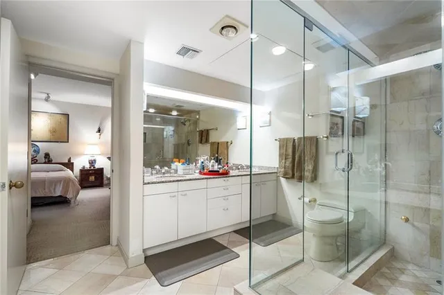a bathroom with a tub a mirror and a shower