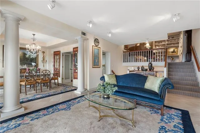 a living room with furniture and a glass table with rug