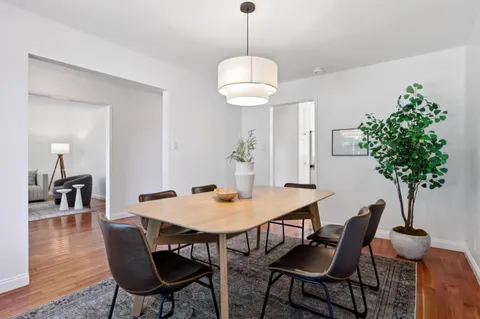 a kitchen with a white cabinets and wooden floor