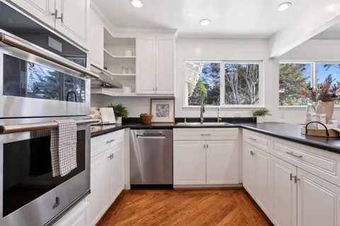 a kitchen with stainless steel appliances granite countertop a refrigerator and a stove top oven