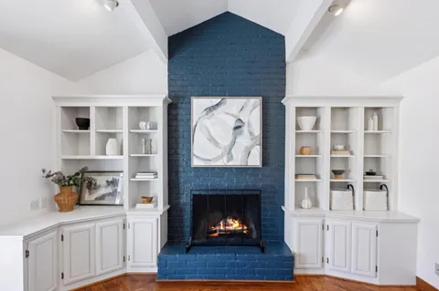 a bedroom with a bed a chair and next to a window