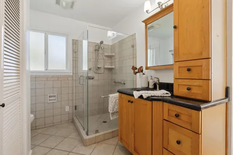 a bathroom with a granite countertop sink a mirror and a bathtub