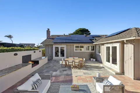 a view of a house with backyard and sitting area