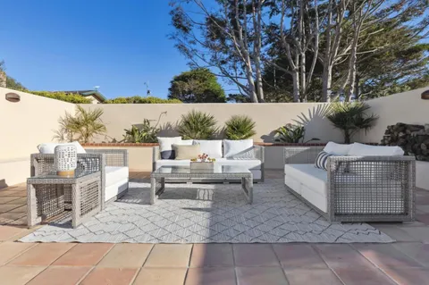 a view of a patio with dining table and chairs with wooden fence