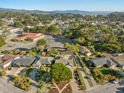 a view of a hallway with wooden floor and a bathroom