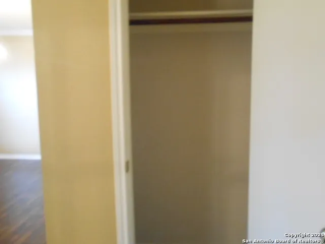 a view of a small space with wooden floor and a window