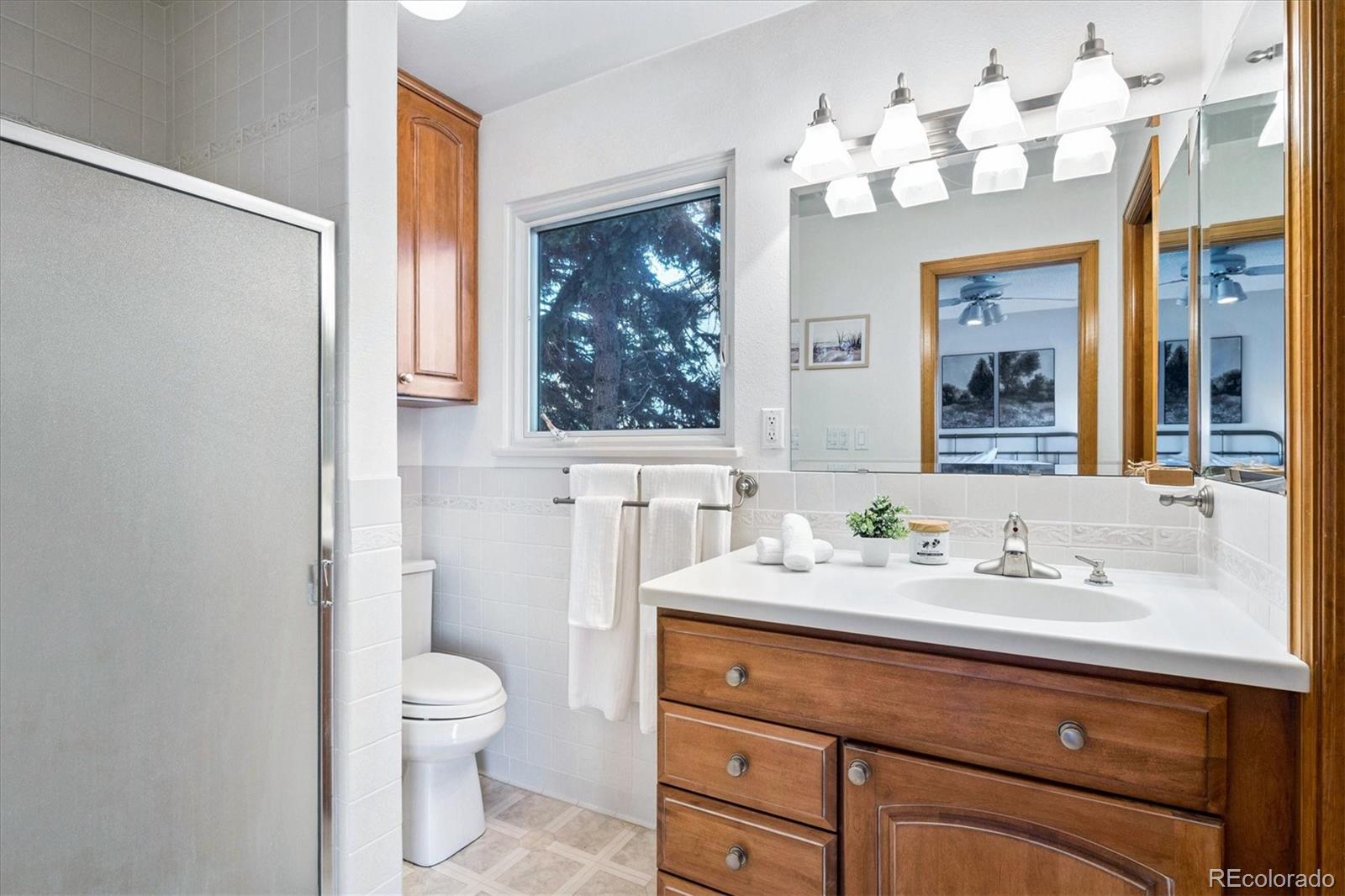 14935 West 58th Place Golden, CO 80403 - Photo 11 of 31 a bathroom with a sink vanity mirror and toilet