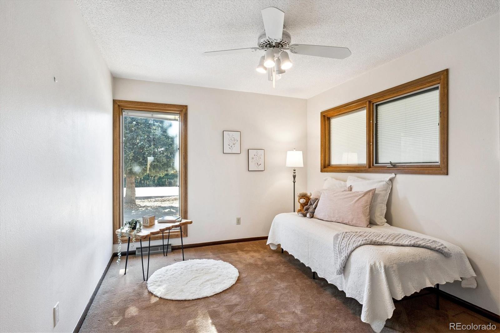 14935 West 58th Place Golden, CO 80403 - Photo 13 of 31 a bedroom with a bed a chandelier and a window