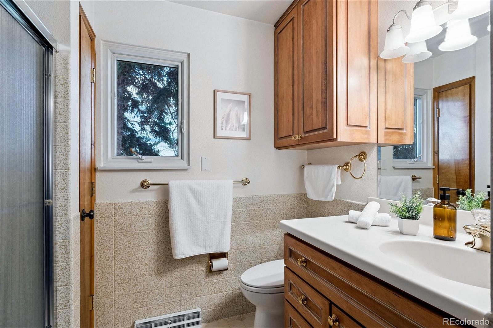 14935 West 58th Place Golden, CO 80403 - Photo 14 of 31 a bathroom with a granite countertop toilet sink and mirror
