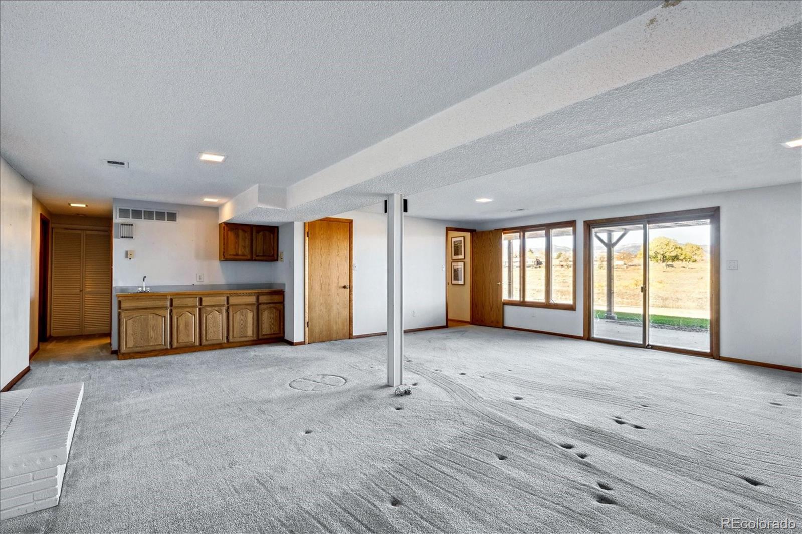 14935 West 58th Place Golden, CO 80403 - Photo 16 of 31 a view of an empty room with window and kitchen view