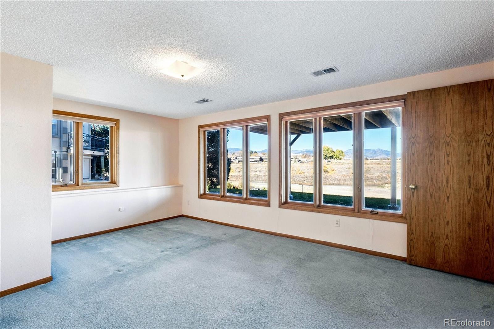 14935 West 58th Place Golden, CO 80403 - Photo 18 of 31 an empty room with windows and view of kitchen