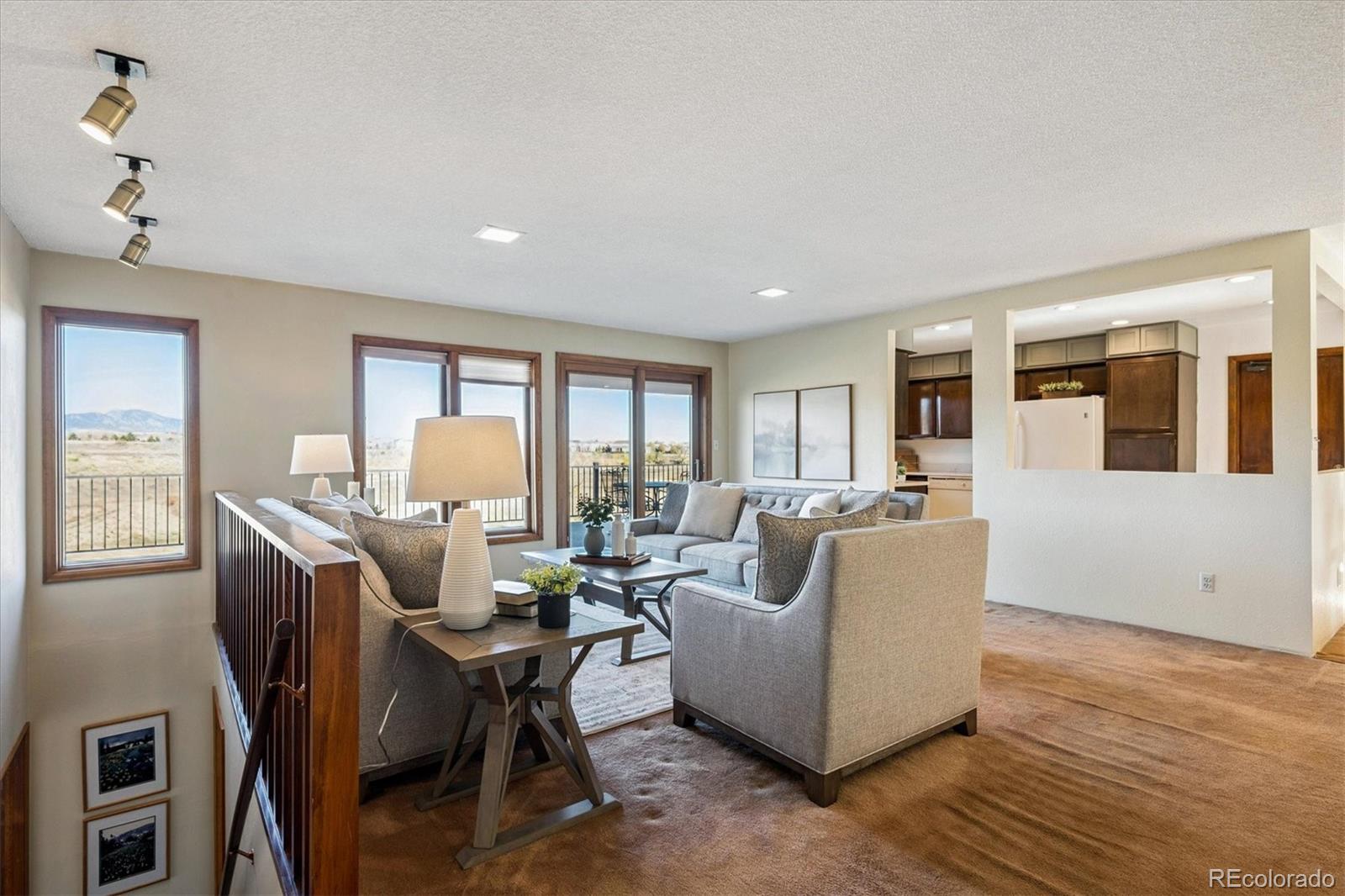 14935 West 58th Place Golden, CO 80403 - Photo 4 of 31 a living room with couches a coffee table and a large window with wooden floor