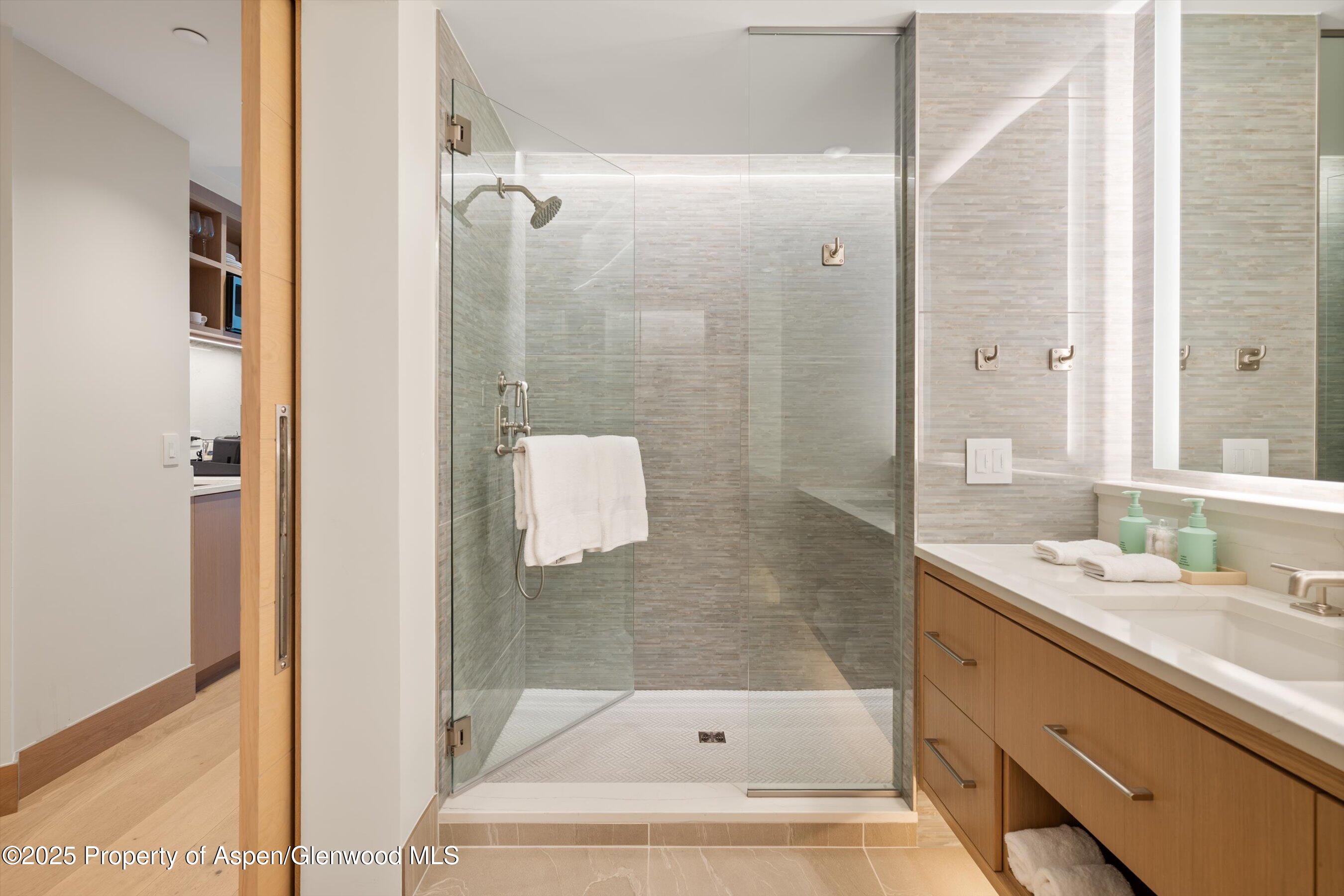 130 Wood Road, Unit 353355 Snowmass Village, CO 81615 - Photo 13 of 41 a bathroom with a bathtub shower sink and mirror