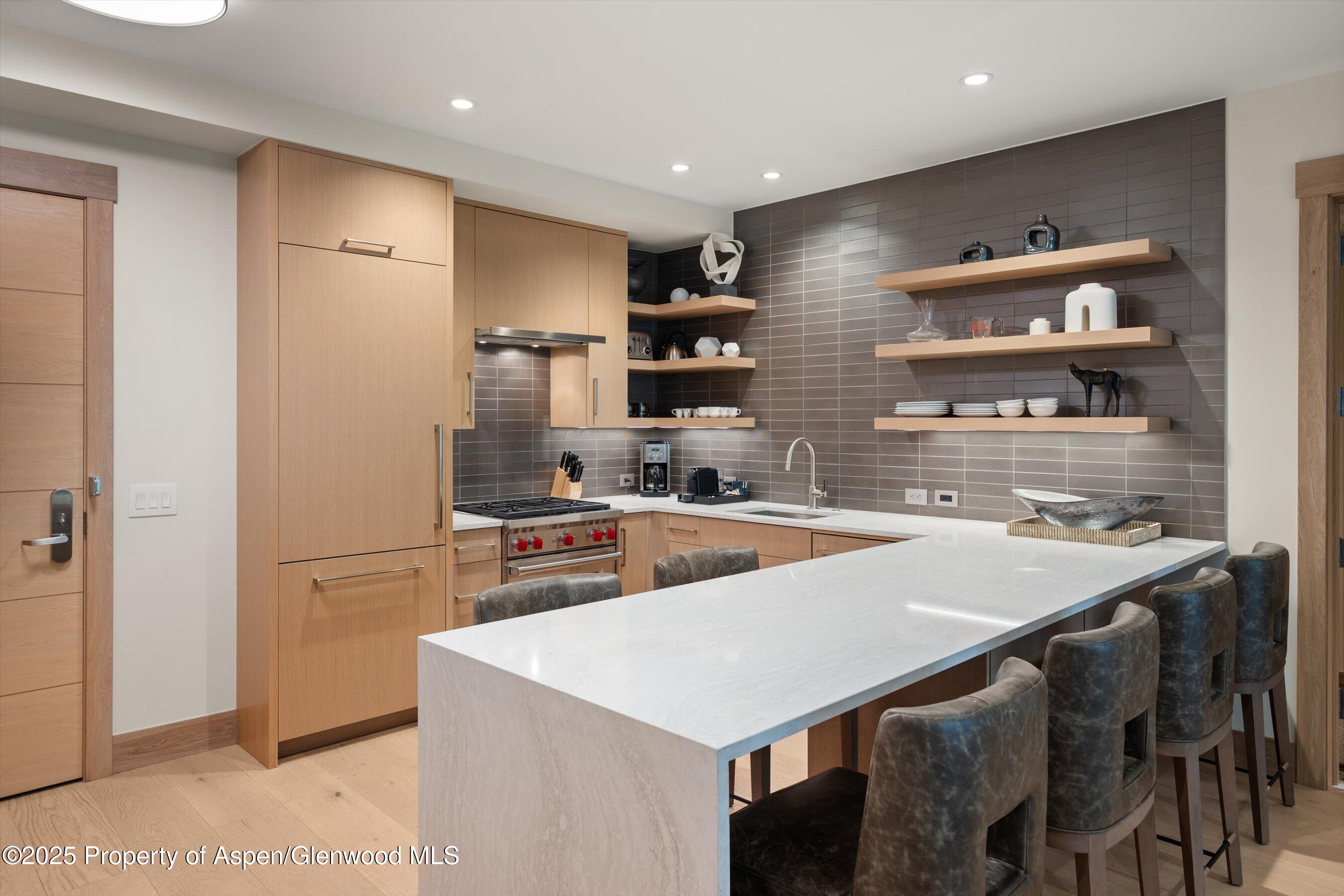 130 Wood Road, Unit 353355 Snowmass Village, CO 81615 - Photo 22 of 41 a kitchen with stainless steel appliances a table and chairs