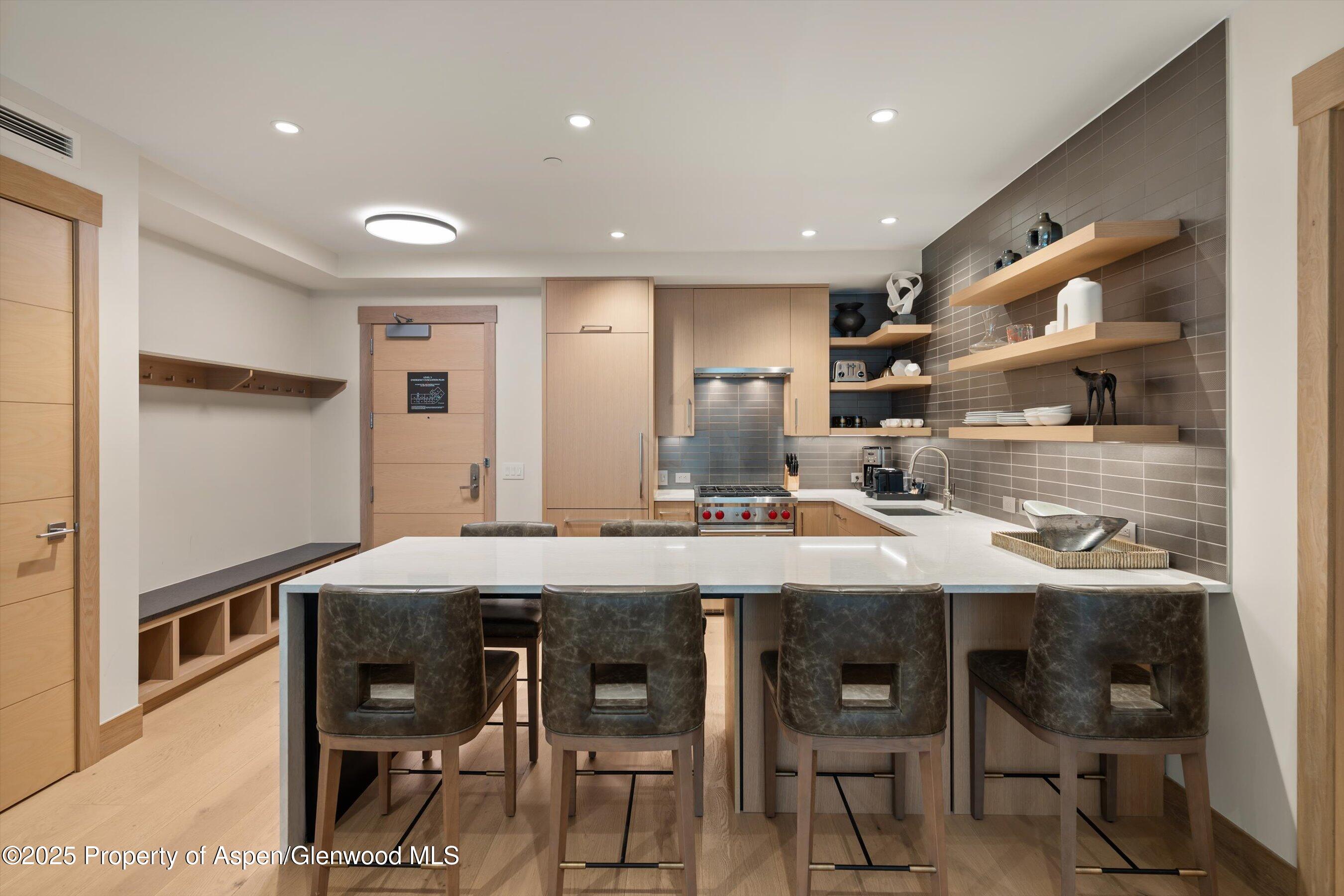 130 Wood Road, Unit 353355 Snowmass Village, CO 81615 - Photo 24 of 41 a kitchen with kitchen island a dining table chairs cabinets and stainless steel appliances
