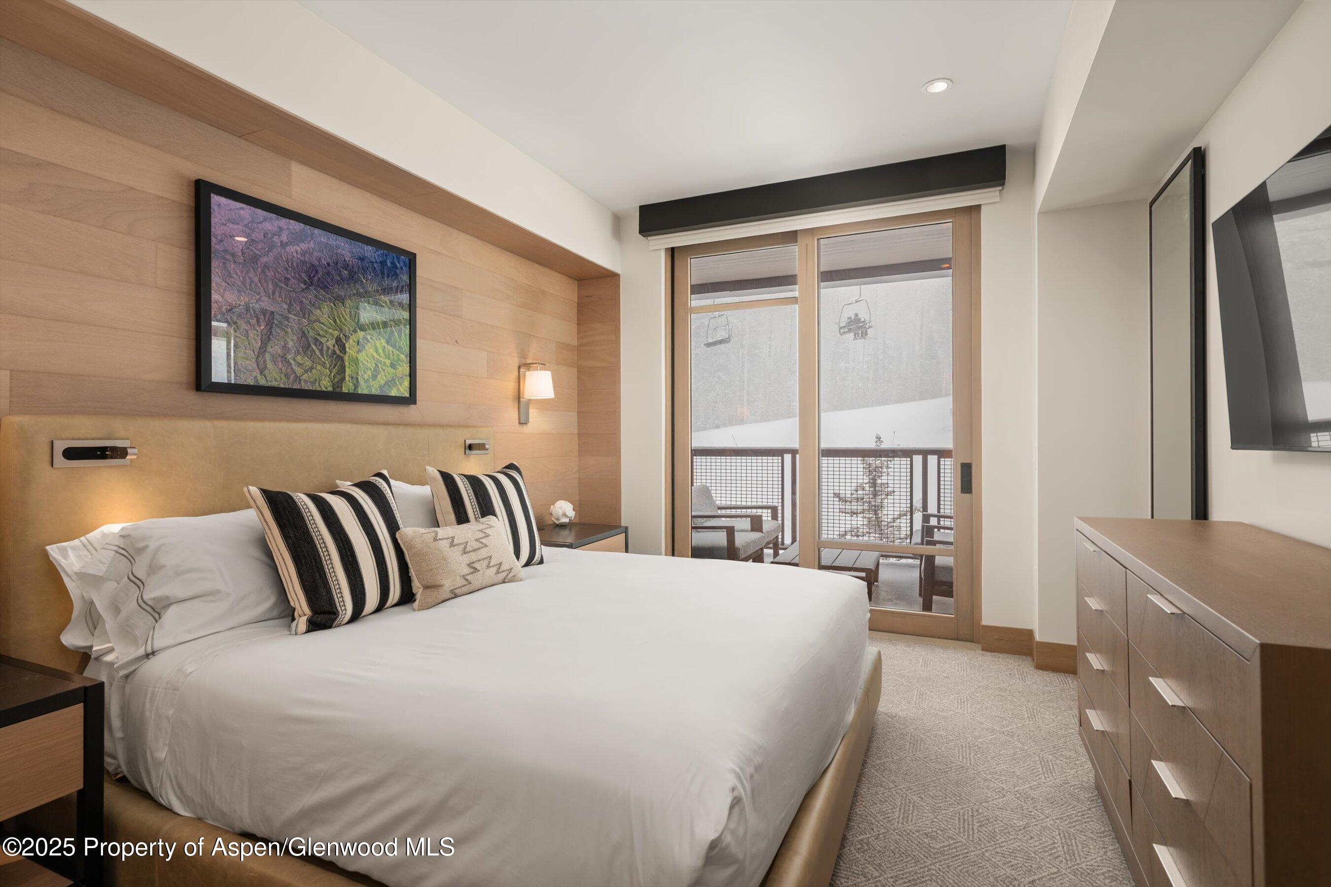 130 Wood Road, Unit 353355 Snowmass Village, CO 81615 - Photo 32 of 41 a spacious bedroom with a bed and glass windows