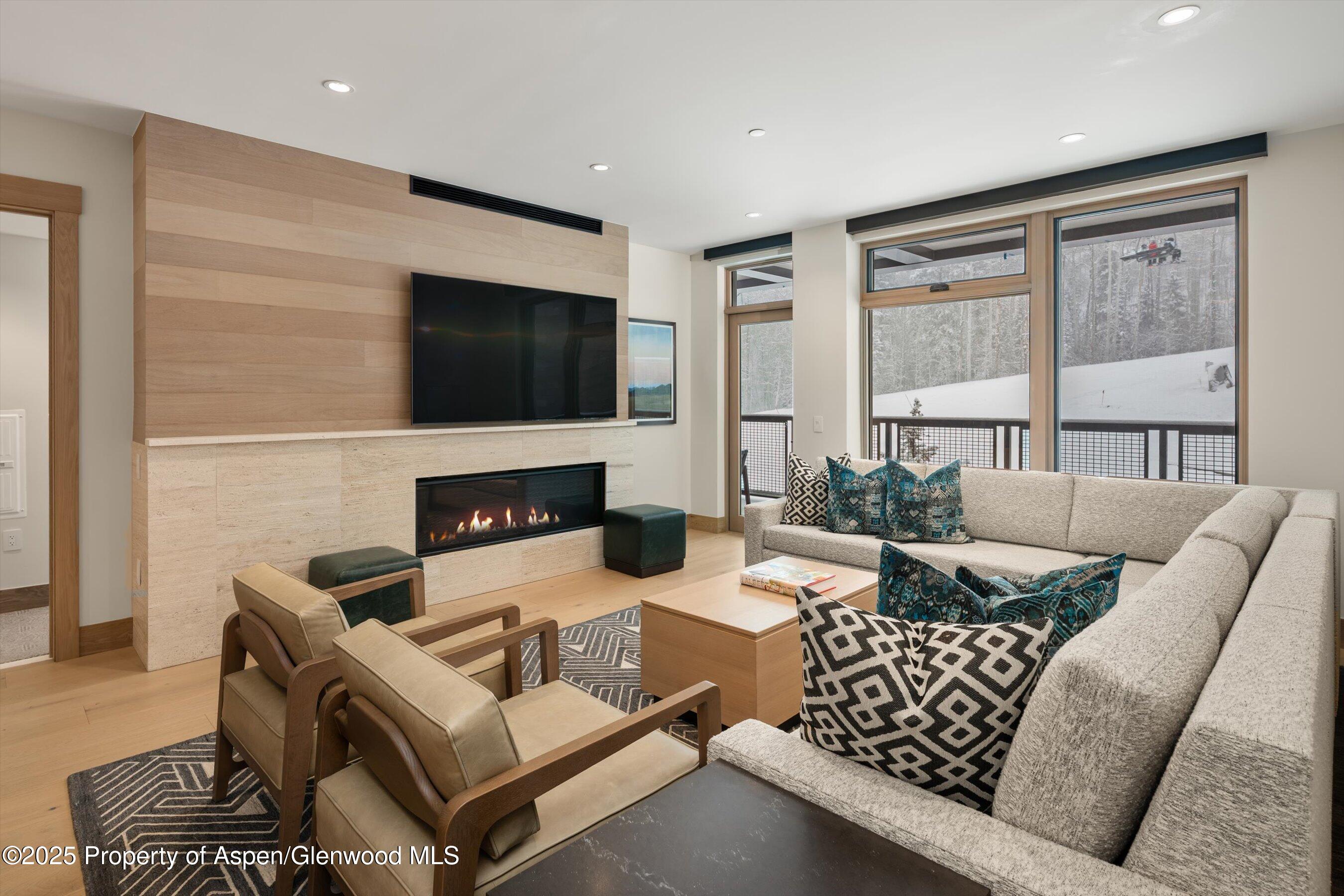 130 Wood Road, Unit 353355 Snowmass Village, CO 81615 - Photo 4 of 41 a living room with furniture a flat screen tv and a fireplace