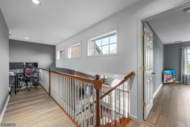 a view of a hallway with wooden floor and stairs