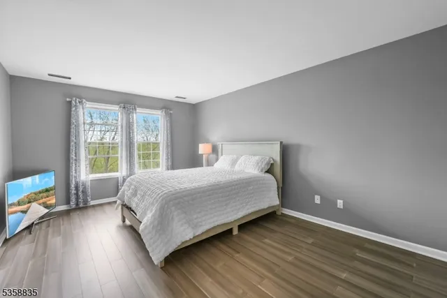 a bedroom with a bed and a large window