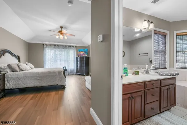 a spacious bathroom with a granite countertop sink a mirror and a bathtub