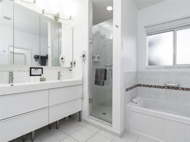 a bathroom with a tub sink shower and mirror