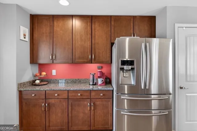 a kitchen with stainless steel appliances granite countertop a refrigerator and a stove top oven