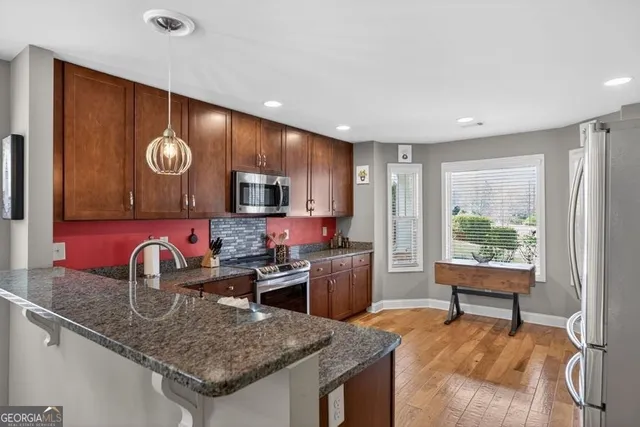 a kitchen with refrigerator and chairs