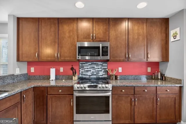 a kitchen with stainless steel appliances granite countertop wooden cabinets stove top oven and sink